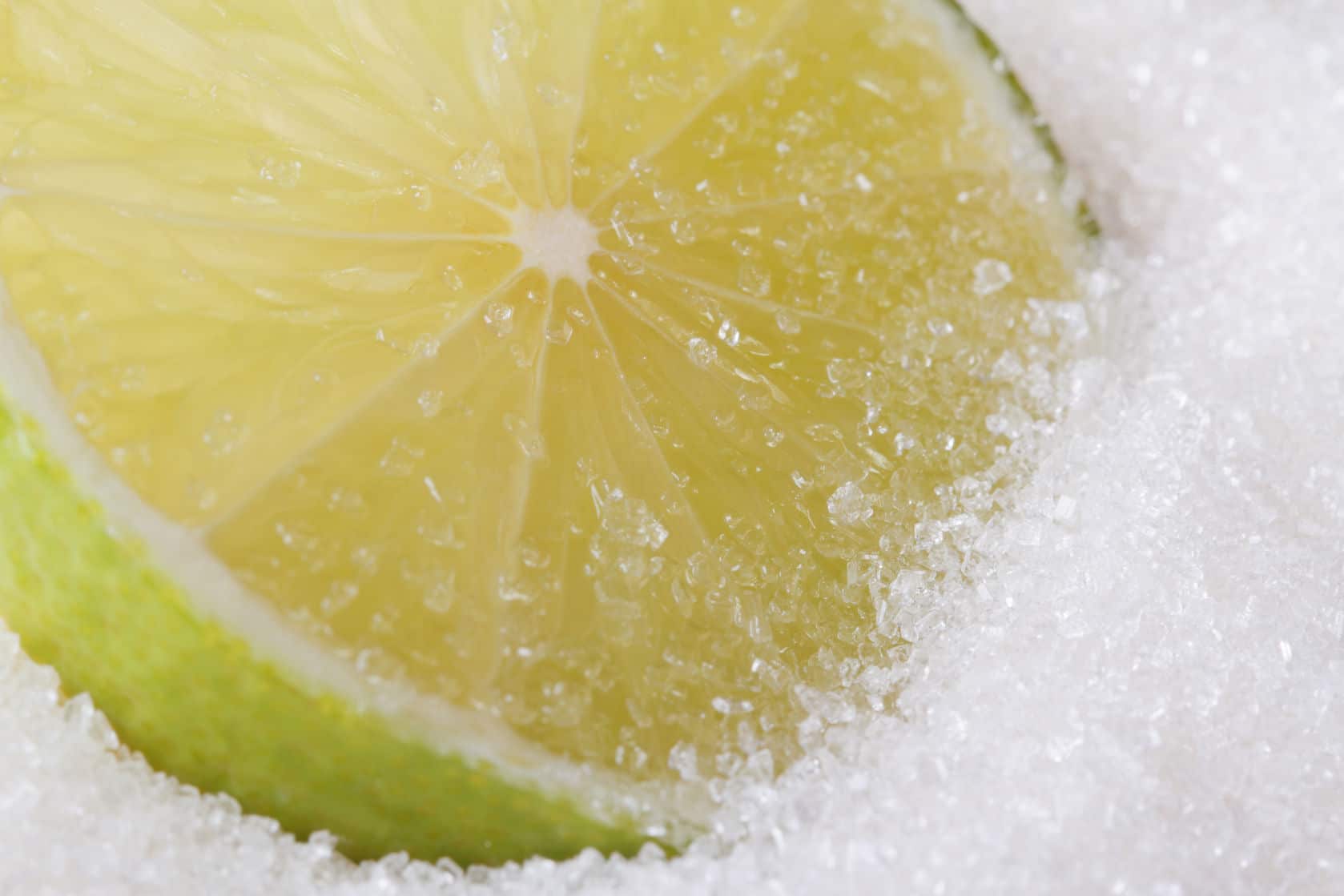 25087029 - slice of fresh lime in sugar closeup